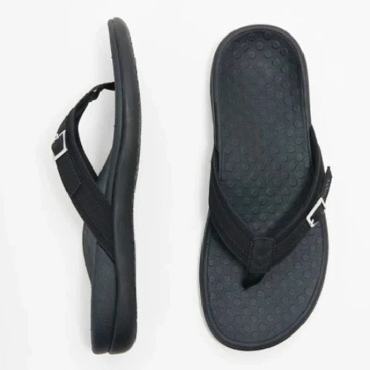 Modell som går med grå ortopediske flip-flops, viser komfort og lett fottøy.
