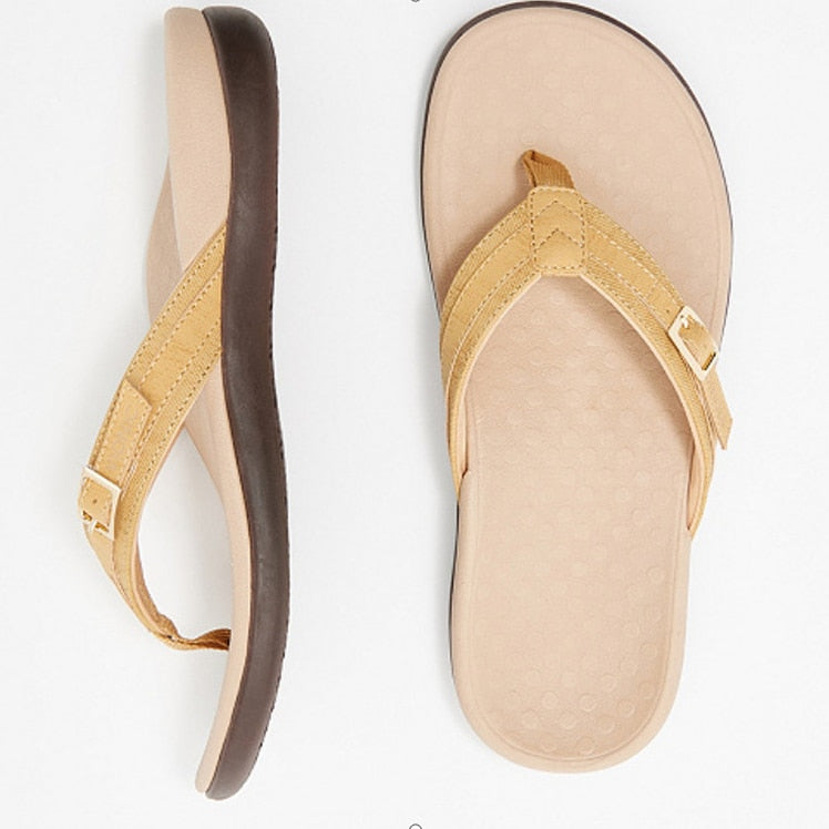 Bilde av flip-flops på en strand, understreker at dette er ortopediske sommersko.