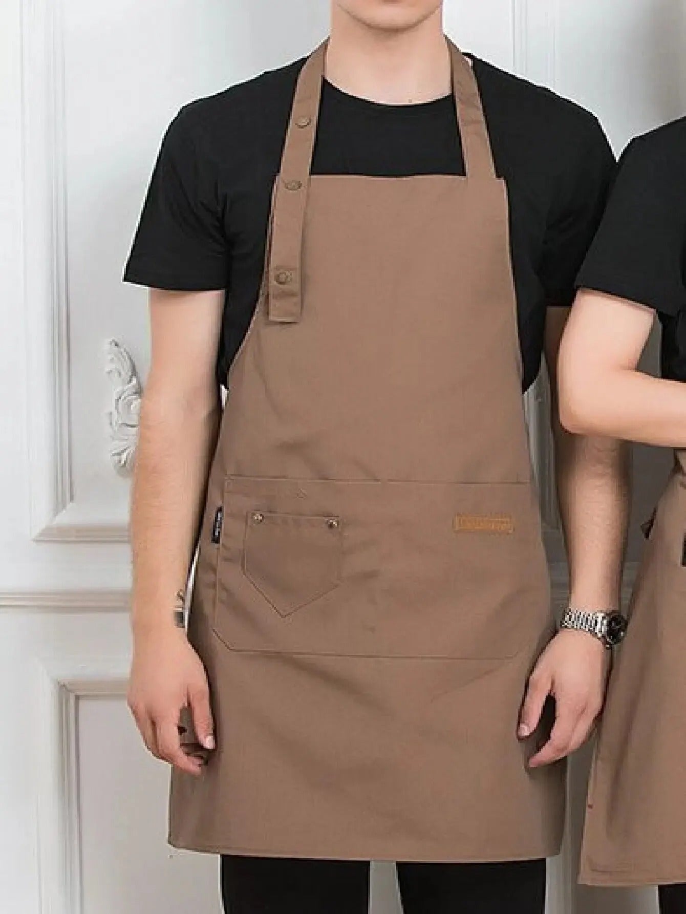 Nærbilde av glatt, vanntett materiale på et unisex kjøkkenforkle, perfekt for matlaging og baking.
