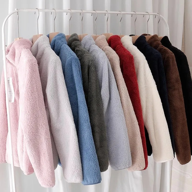 Kvinne iført beige vendbar fleecejakke, smilende og aktiv, klar for utendørsaktiviteter.