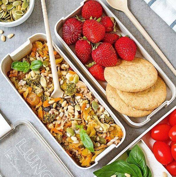 Viser 3-lags bento matboks i bruk, fylt med mat, understreker dens praktiske design og lekkasjesikre funksjon.