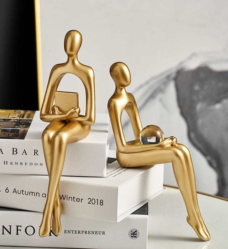 To abstrakte harpiksfigurer som en moderne skulpturell dekorasjon for hyller og bord.