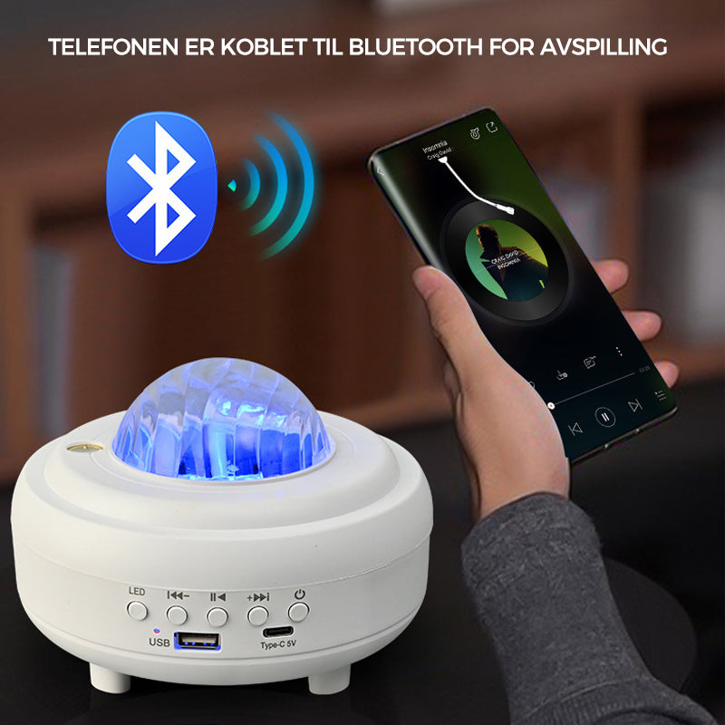 "Auroraprojektor med galakselys i rommet, elegant svart-hvitt design, Bluetooth-høyttaler for dynamisk lysopplevelse."