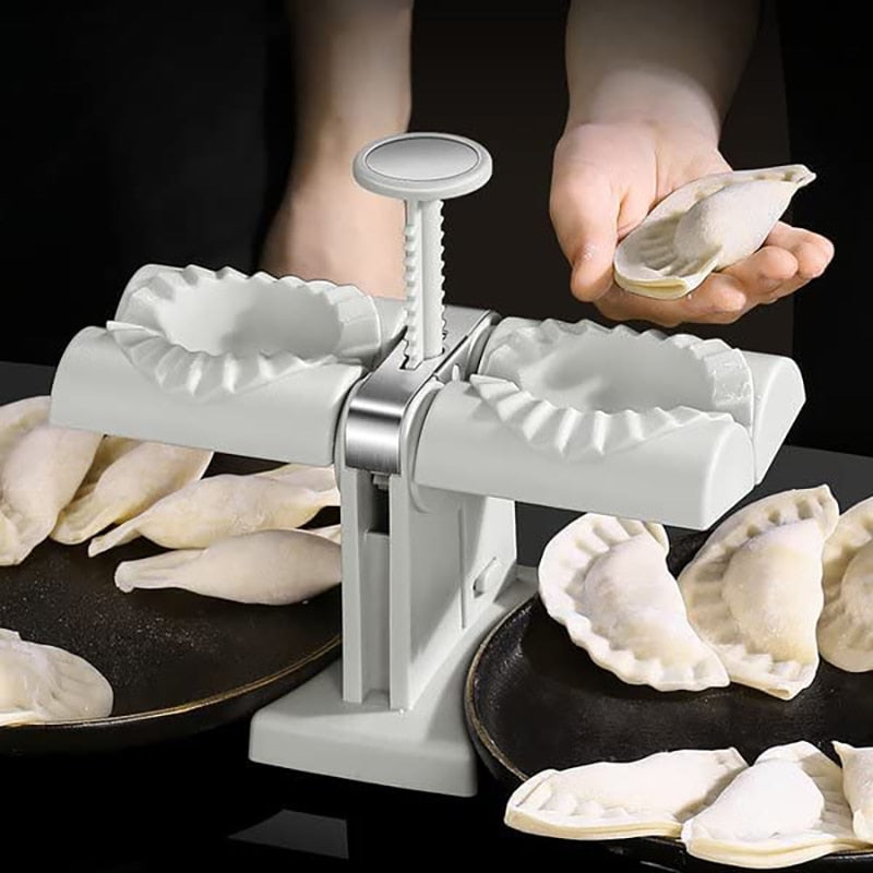 Nærbilde av den automatiske dumplingformeren som presser deig til en perfekt halvmåneformet dumpling.