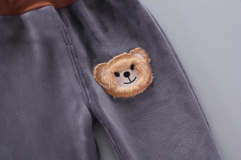 Baby vinterdress med bjørnedesign, fra ryggen, viser hette med ører og mykt materiale.