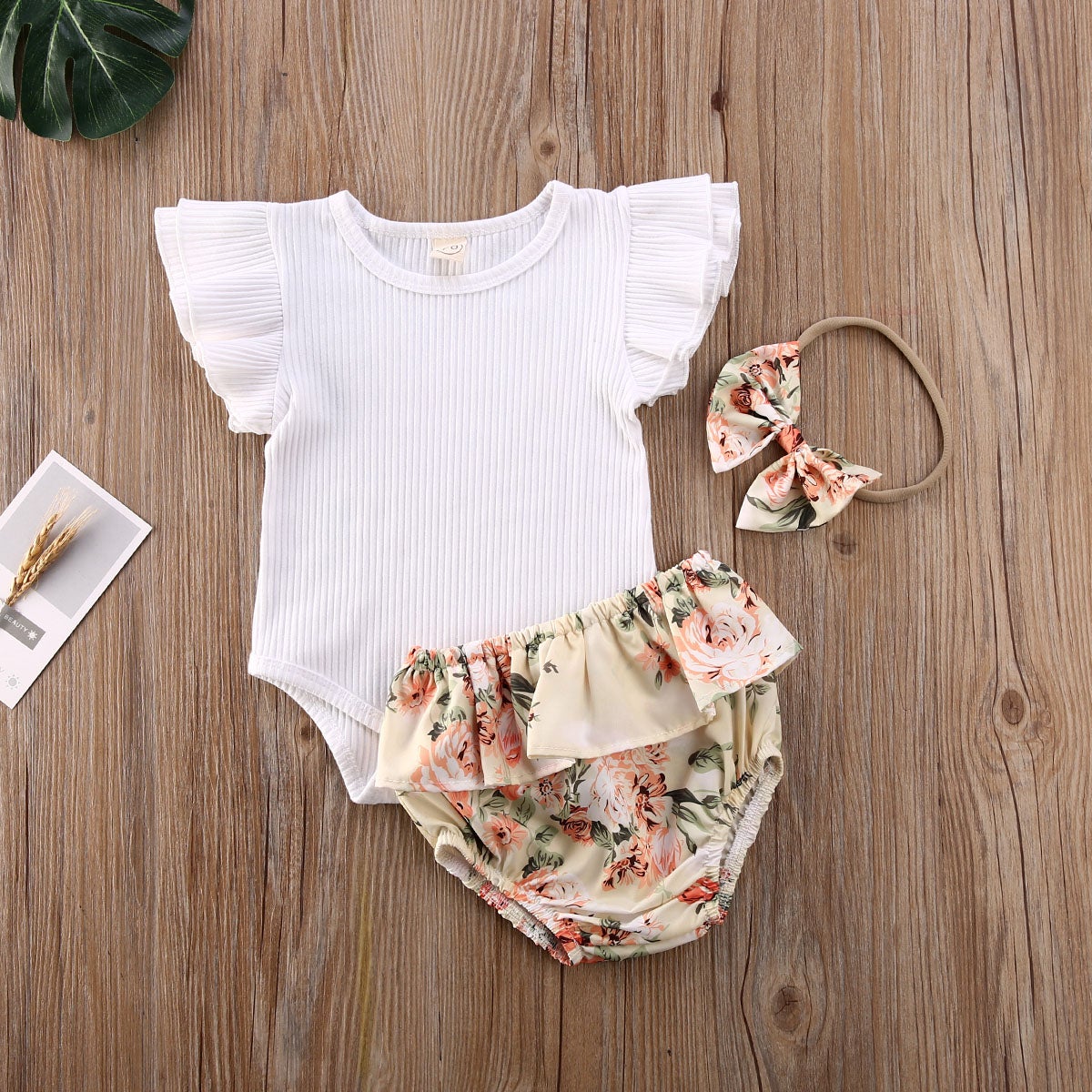 Nydelig babyjente shorts sett med blomsterprint, volanger, ribbet stoff og pannebånd, perfekt for sommeren.