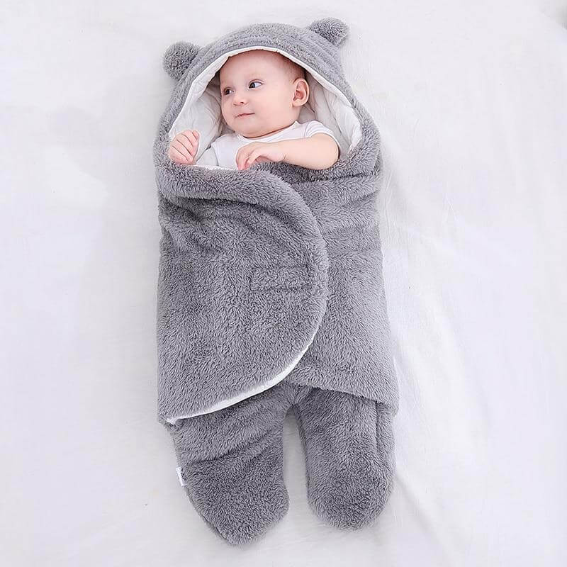 DIY babypledd sovepose på en treoverflate, rustikk stemning.