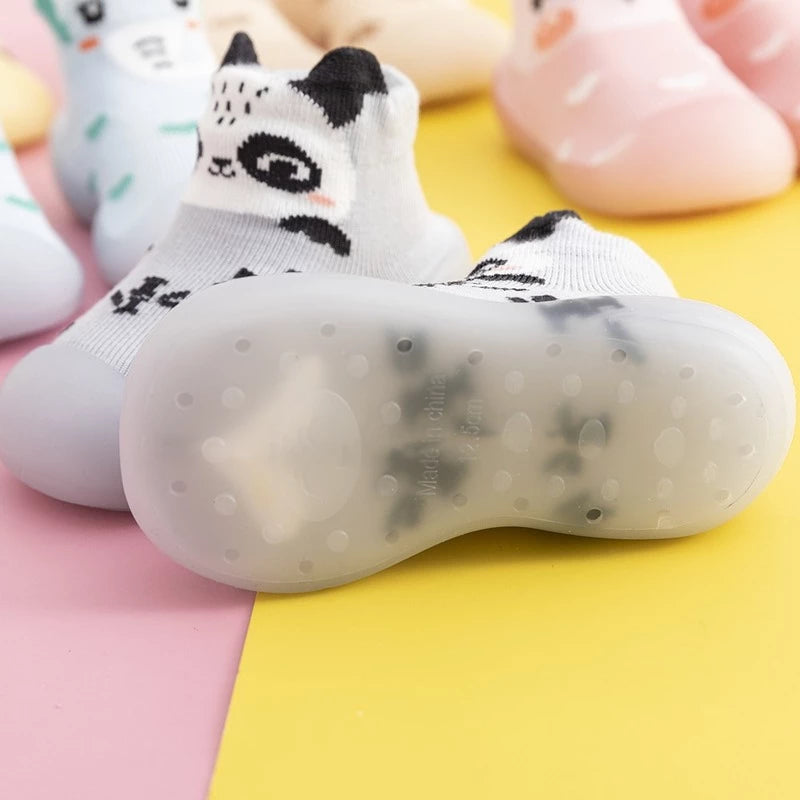 Detaljert bilde av antiskli gummisåle på strikkede babysokkesko for spedbarn