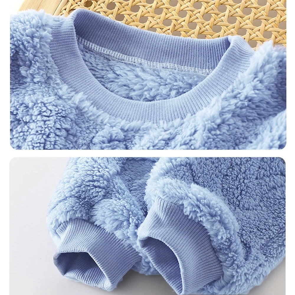 Pyjamas til gutt i tykk, rutete flanell, perfekt for kalde vinternetter, vises hengende.