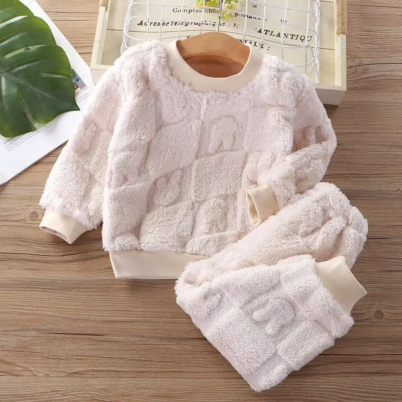 Detaljert bilde av flanellstoffet på barnas pyjamas, viser myk tekstur og mønster.