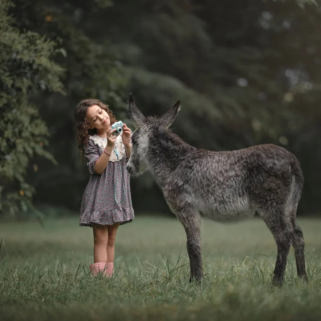 Glad jente tar bilde med et fargerikt barnekamera, forbedrer kreativitet og øye-hånd-koordinasjon.