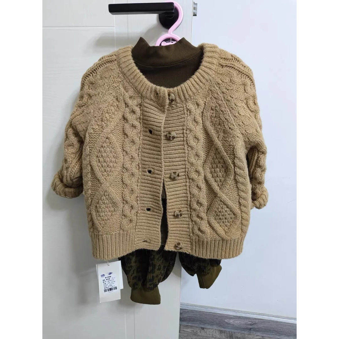 Detalj av hals og ermer på en komfortabel barnestrikkegenser i myk bomull, beige farge