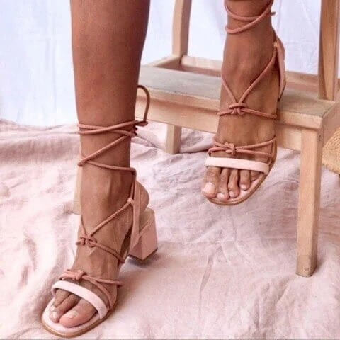 Par svarte og oransje Gladiator-sandaler med snøring, viser stil og allsidighet.