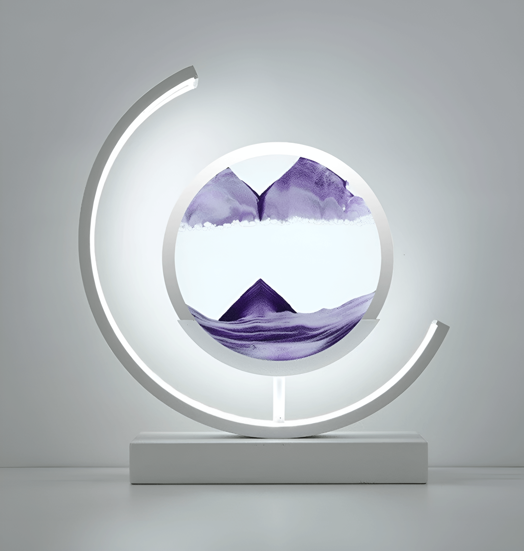 Moderne bordlampe med roterende sandkunst og integrert LED-lys, ideell for stemningsfull belysning.