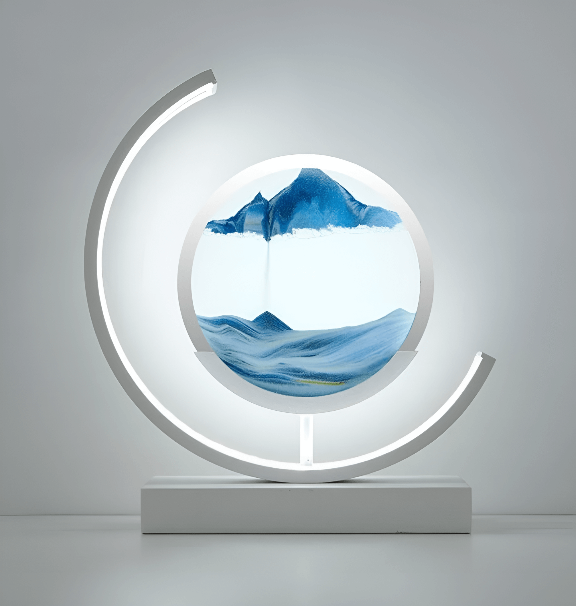 Timeglasslampe med skiftende sandkunstlandskap og mykt LED-lys, skaper en avslappende atmosfære i rommet.