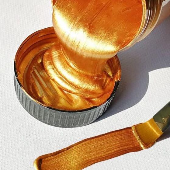 Swatch av flere metalliske akrylmalingfarger på svart bakgrunn, fremhever glansen.