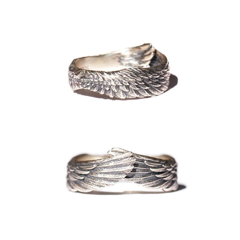 Detaljebilde av unisex englevinge ring i sølv på hvit bakgrunn, viser intrikate fjærdetaljer for et klassisk smykke.