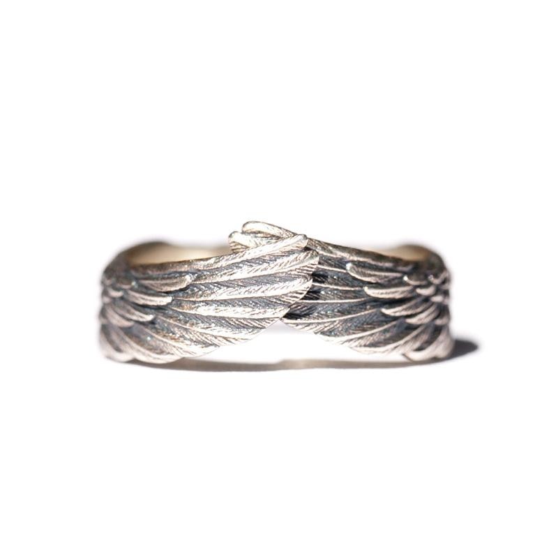 Bilde av en modellhånd som bærer en unisex englevinge ring i sølv, fremhever dens stil og beskyttende design som gaveidé.