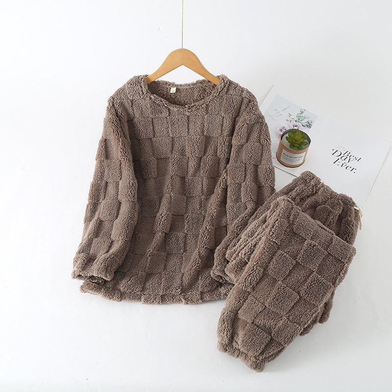 Bilde av en kvinne som drikker te iført rutete loungewear sett, understreker komfort og hygge for vinterkvelder.