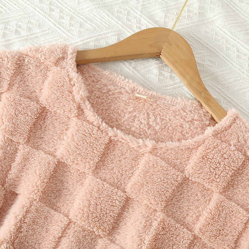 Teksturert nærbilde av det rutete mønsteret på pyjamassettet, viser fargene og mykheten i stoffet, damemote.