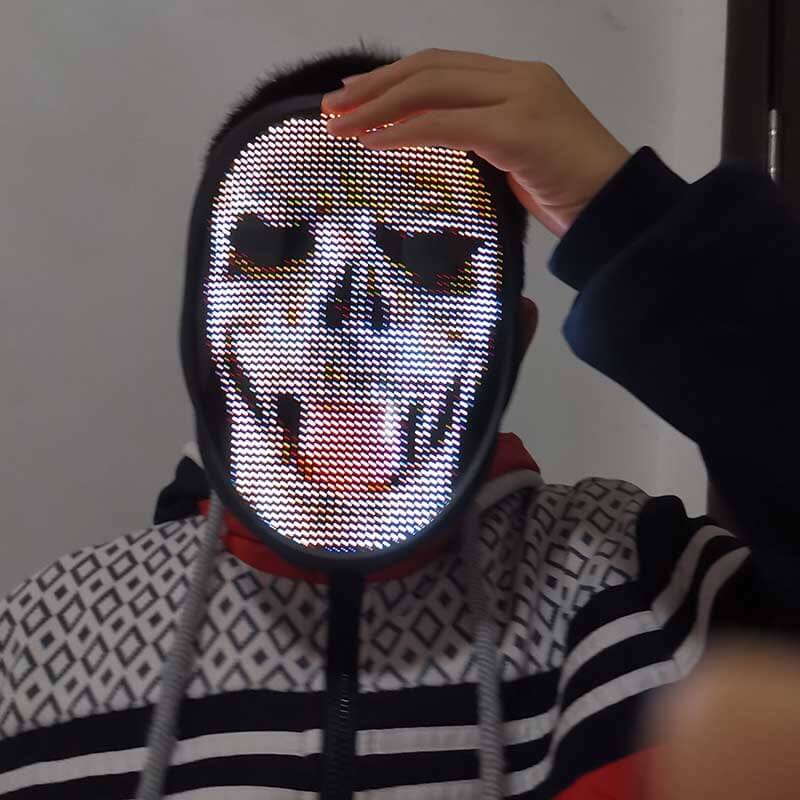 Person som bruker en glødende Halloween LED-maske med Bluetooth-styring, skaper en skummel feststemning.