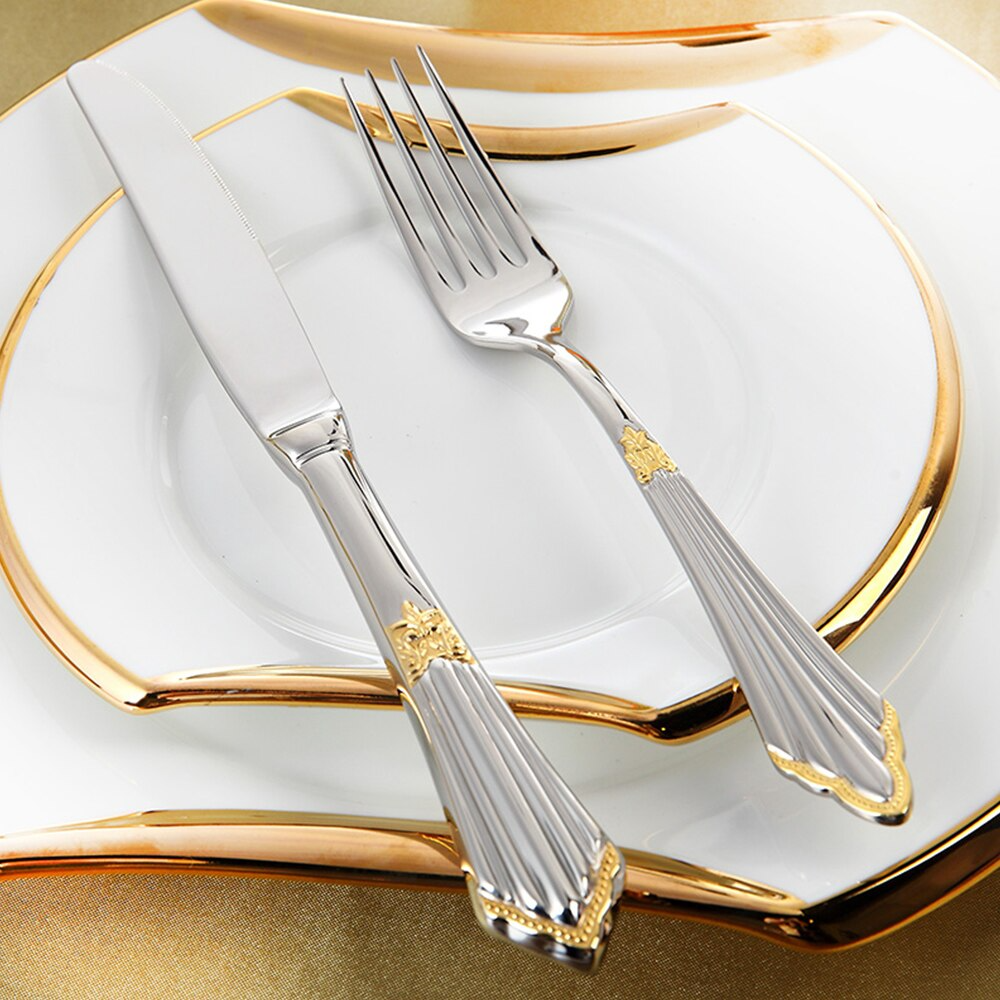Elegant bestikksett i rustfritt stål pent arrangert på et middagsbord. Perfekt for stilfull borddekking.