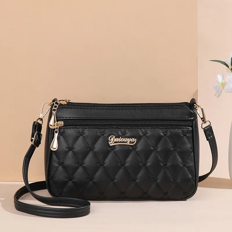 Sidevisning av brodert PU-skinn crossbody-veske, en fasjonabel veske for kvinner, med god plass.