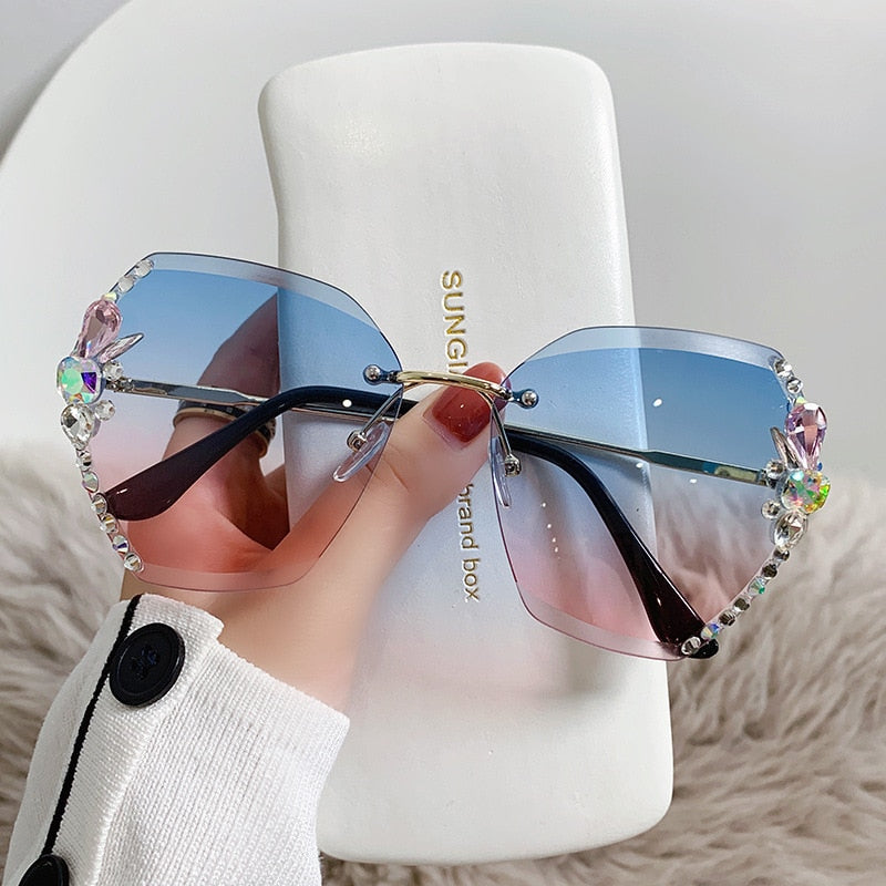 Dame solbrille uten ramme, pyntet med glitrende rhinestones, gir elegant UV400 solbeskyttelse.