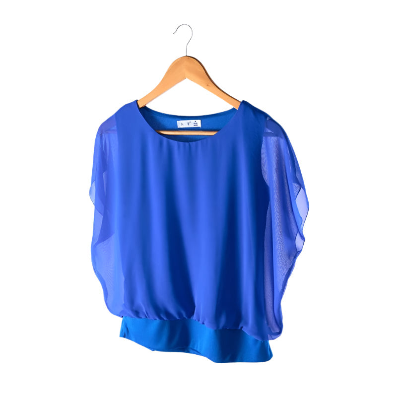 Allsidig damebluse med flaggermusermer og delikate volanger, egnet for enhver anledning.