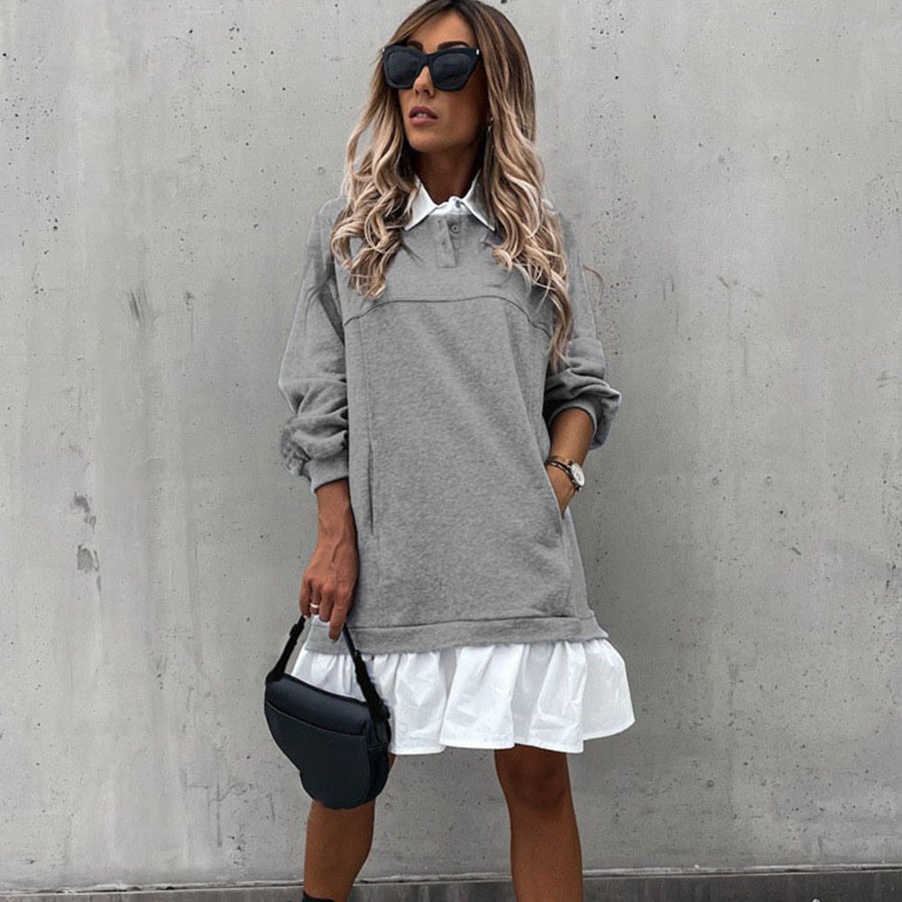 Stilren dame minikjole, sort, med krage og knapper, viser elegant og komfortabel stil