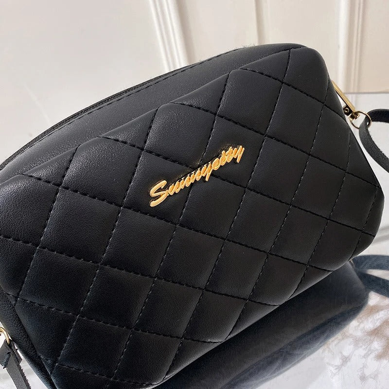 Motebevisst skulderveske i sort med elegant diamant quilting og sikker glidelåslukking.