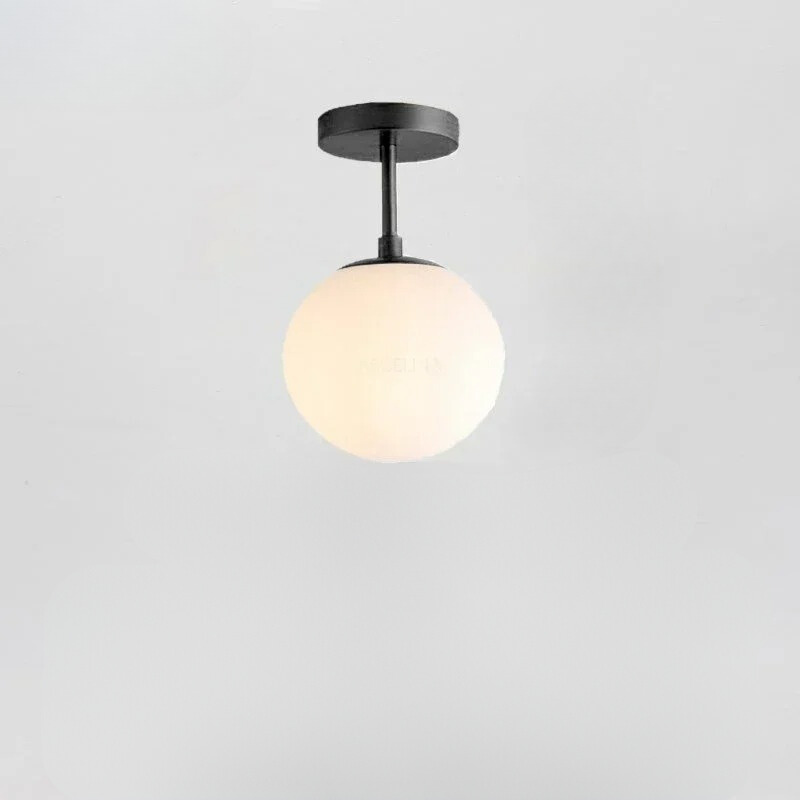 Minimalistisk taklampe med glasskule. Moderne LED-belysning for et stilrent hjem i nordisk stil.