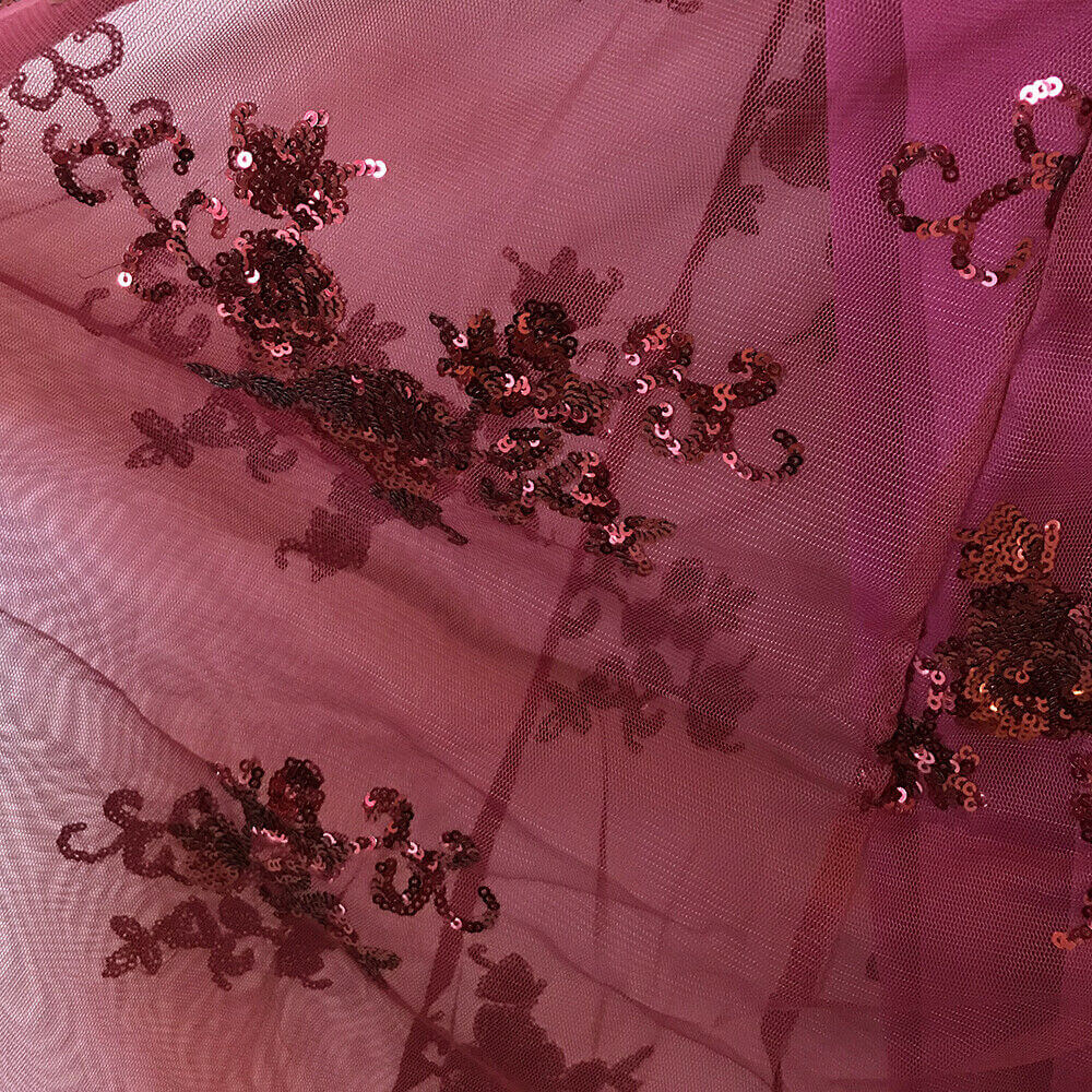 Helkroppsbilde av kvinne i glitrende havfrue aftenkjole, svart med paljetter og elegant slep.