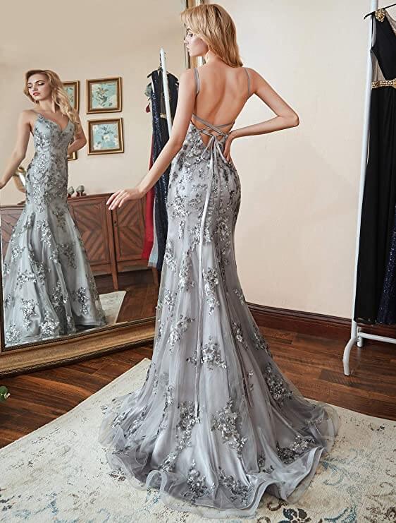 Ryggvisning av lang, svart havfruekjole med krysende spaghettistropper og splitt, elegant aftenkjole.