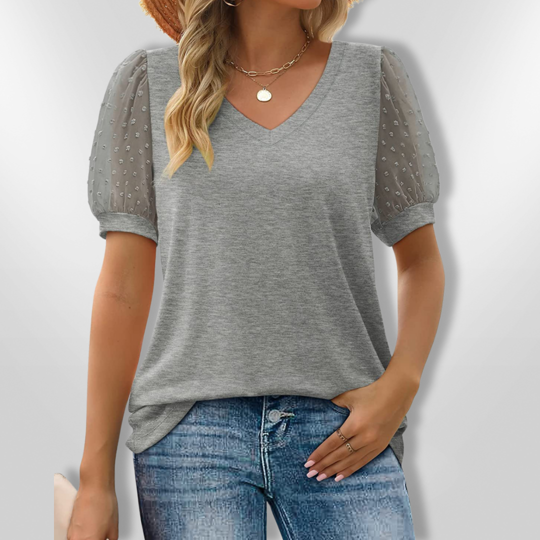 Vakker sommerbluse med V-hals og elegante puffermansjetter, fremhever feminin stil og komfort.