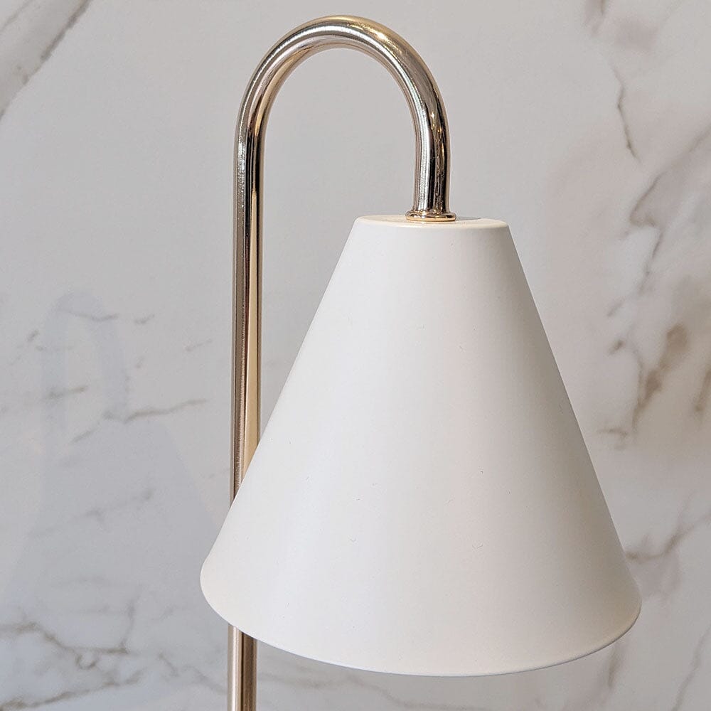 Stilren lysvarmer med hvit og lyseblå base, elegant gullaksent, for trygg bruk av duftlys og moderne interiør.
