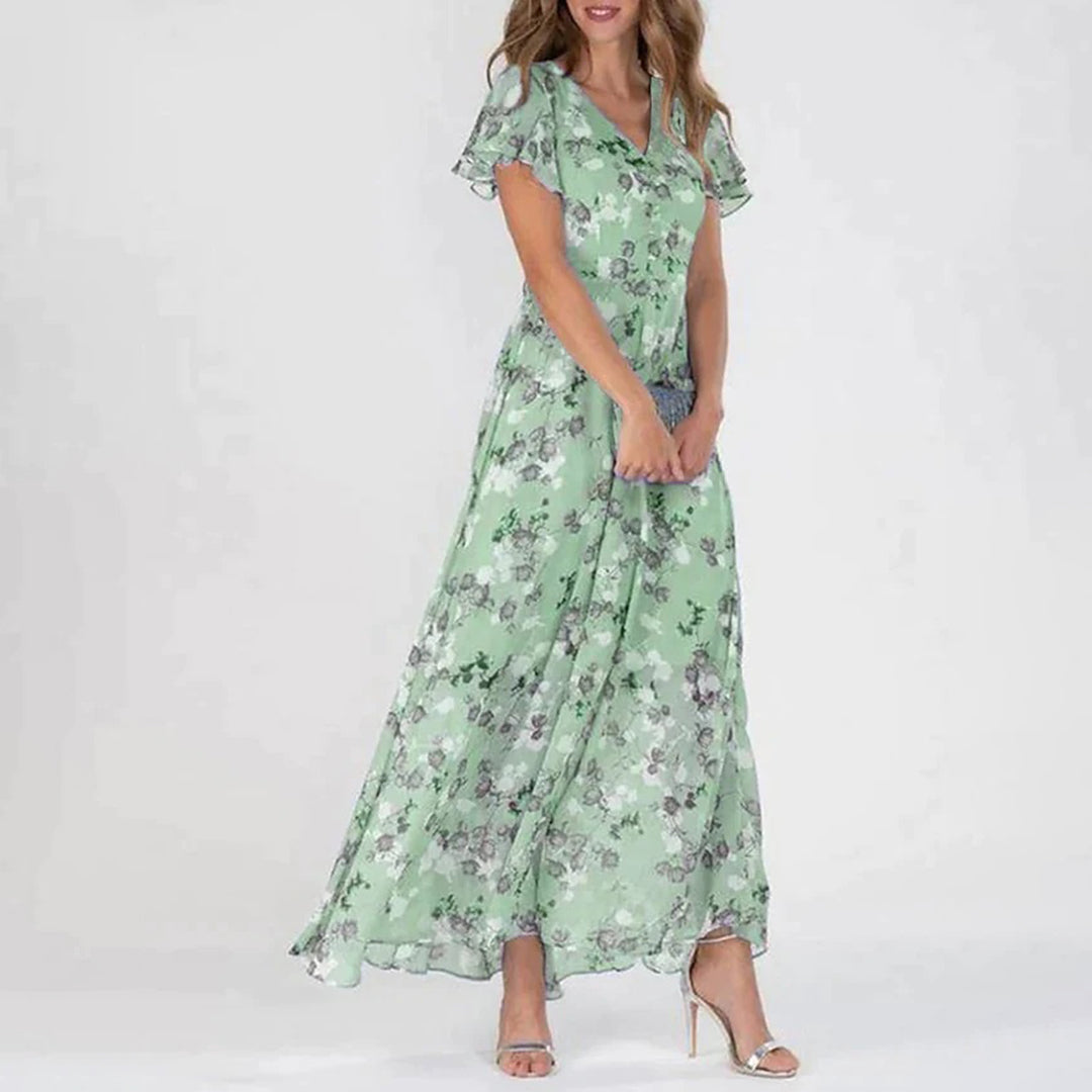 "Elegant maxikjole med blomster, grønn og himmelblå. Perfekt snitt, luftig og komfortabel for sommerdager."
