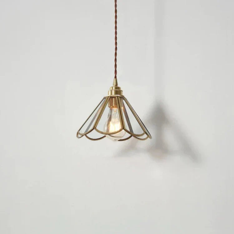 "Elegant pendellampe i messing og klart glass med vintage tvinnet stoffledning, gir en klassisk og moderne belysning."
