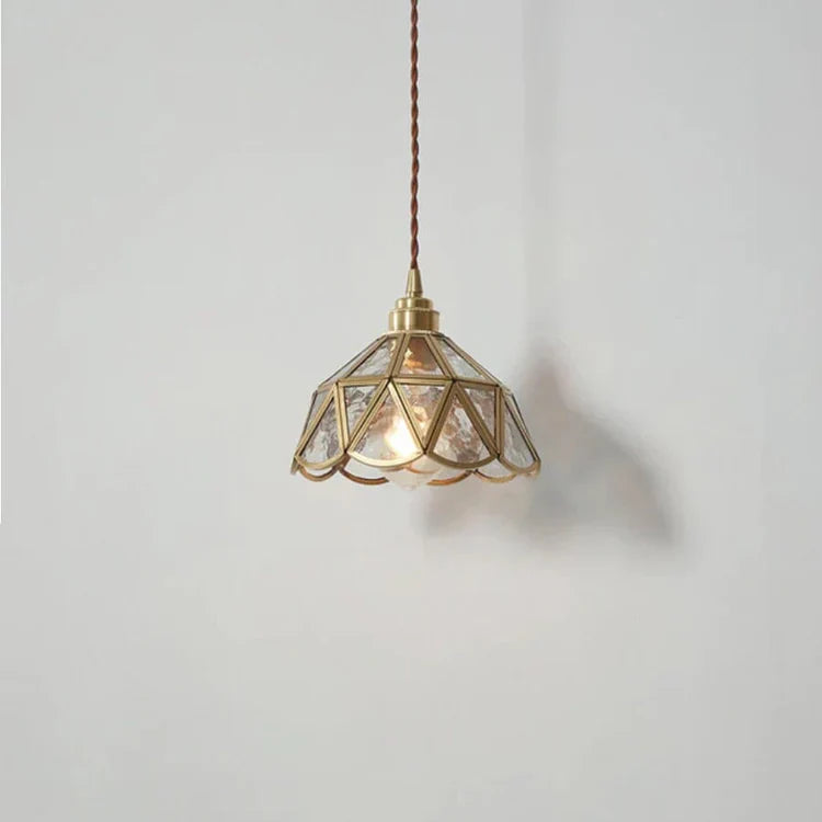 "Elegant pendellampe i messing og klart glass med vintage tvinnet stoffledning, gir en klassisk og moderne belysning."