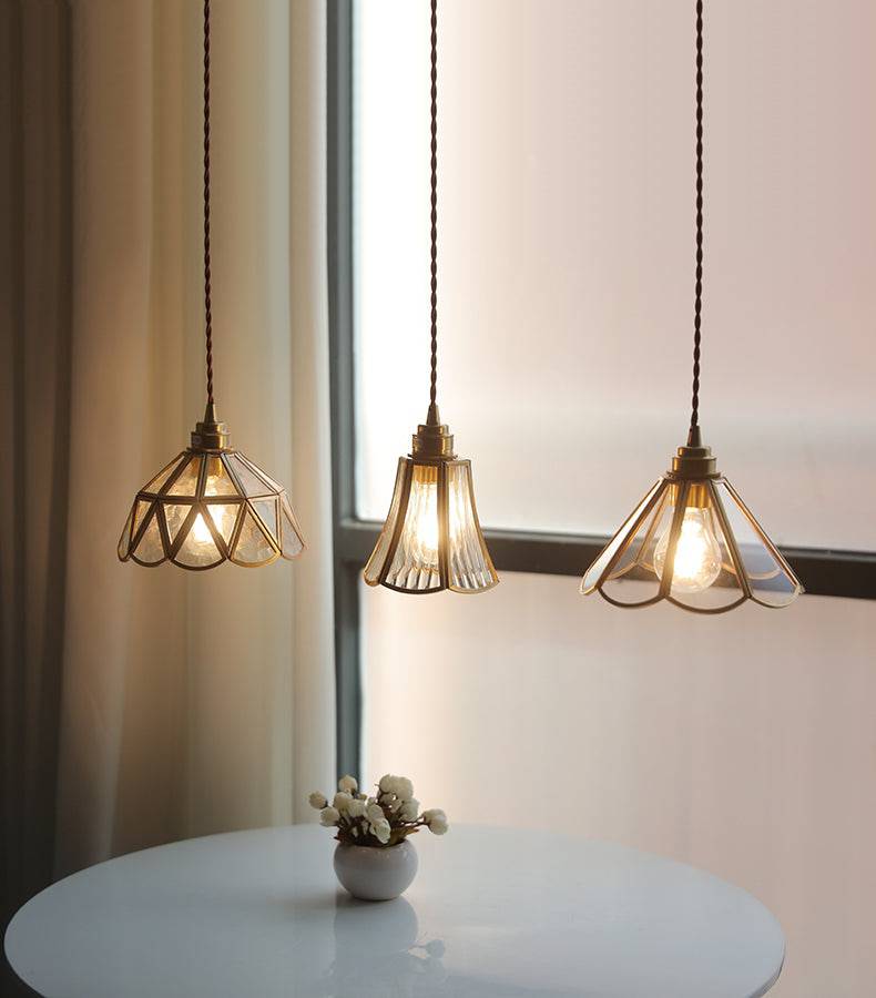 "Elegant pendellampe i messing og klart glass med vintage tvinnet stoffledning, gir en klassisk og moderne belysning."