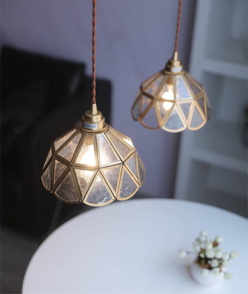 "Elegant pendellampe i messing og klart glass med vintage tvinnet stoffledning, gir en klassisk og moderne belysning."
