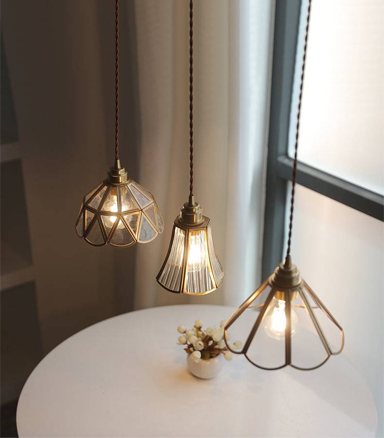 "Elegant pendellampe i messing og klart glass med vintage tvinnet stoffledning, gir en klassisk og moderne belysning."