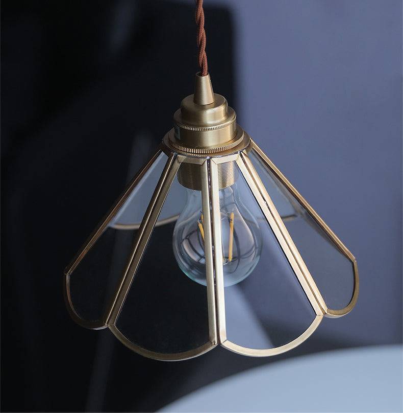 "Elegant pendellampe i messing og klart glass med vintage tvinnet stoffledning, gir en klassisk og moderne belysning."