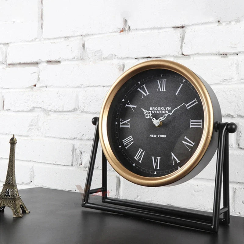 Nærbilde av detaljert retro skrivebordsklokke i gullfarget metall, fremhever dens tidløse design.