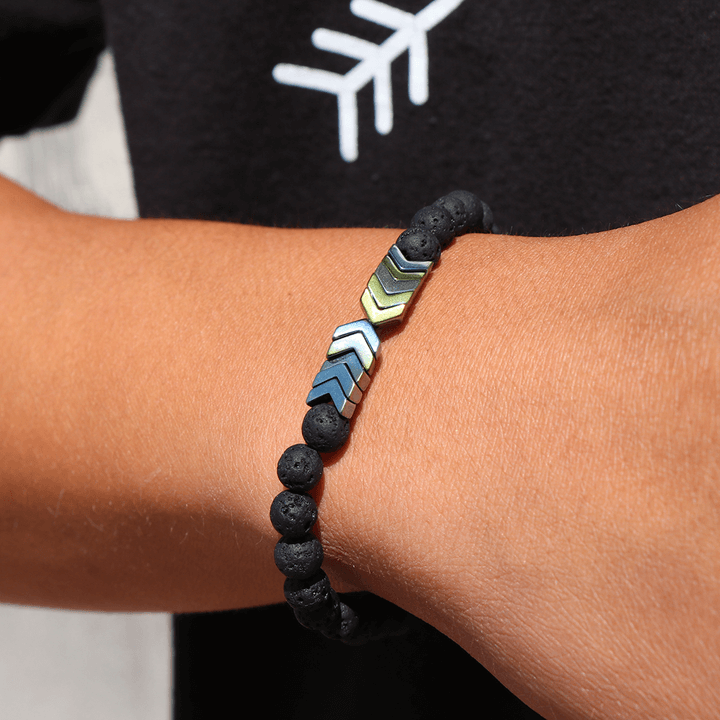 Nærbilde av Sacred Arrow diffuser armbånd med pil, lavastein og hematitt. Aromaterapi smykker.