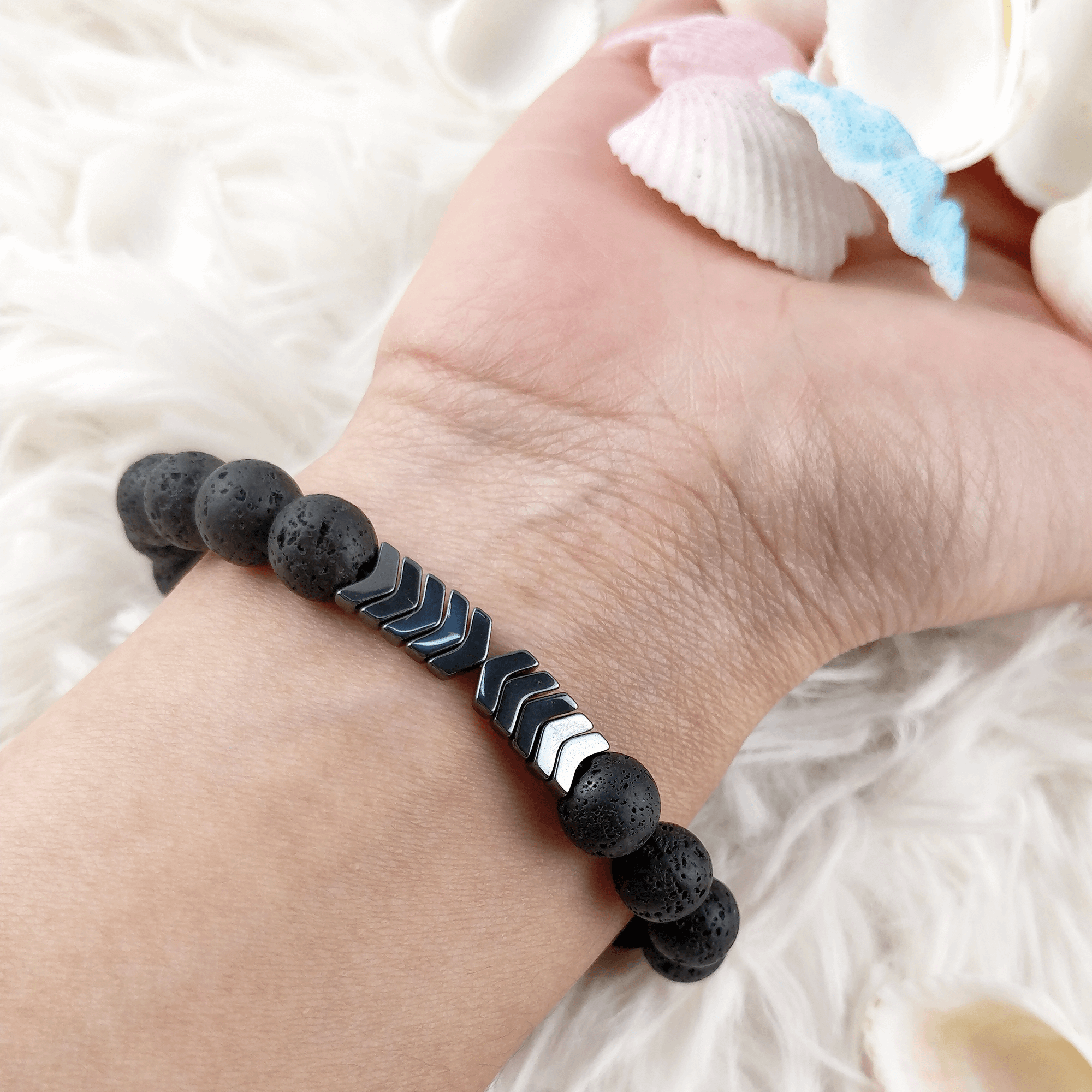 Stilfullt Sacred Arrow diffuser armbånd for kvinner. Kombinerer lavastein, hematitt og krystaller.