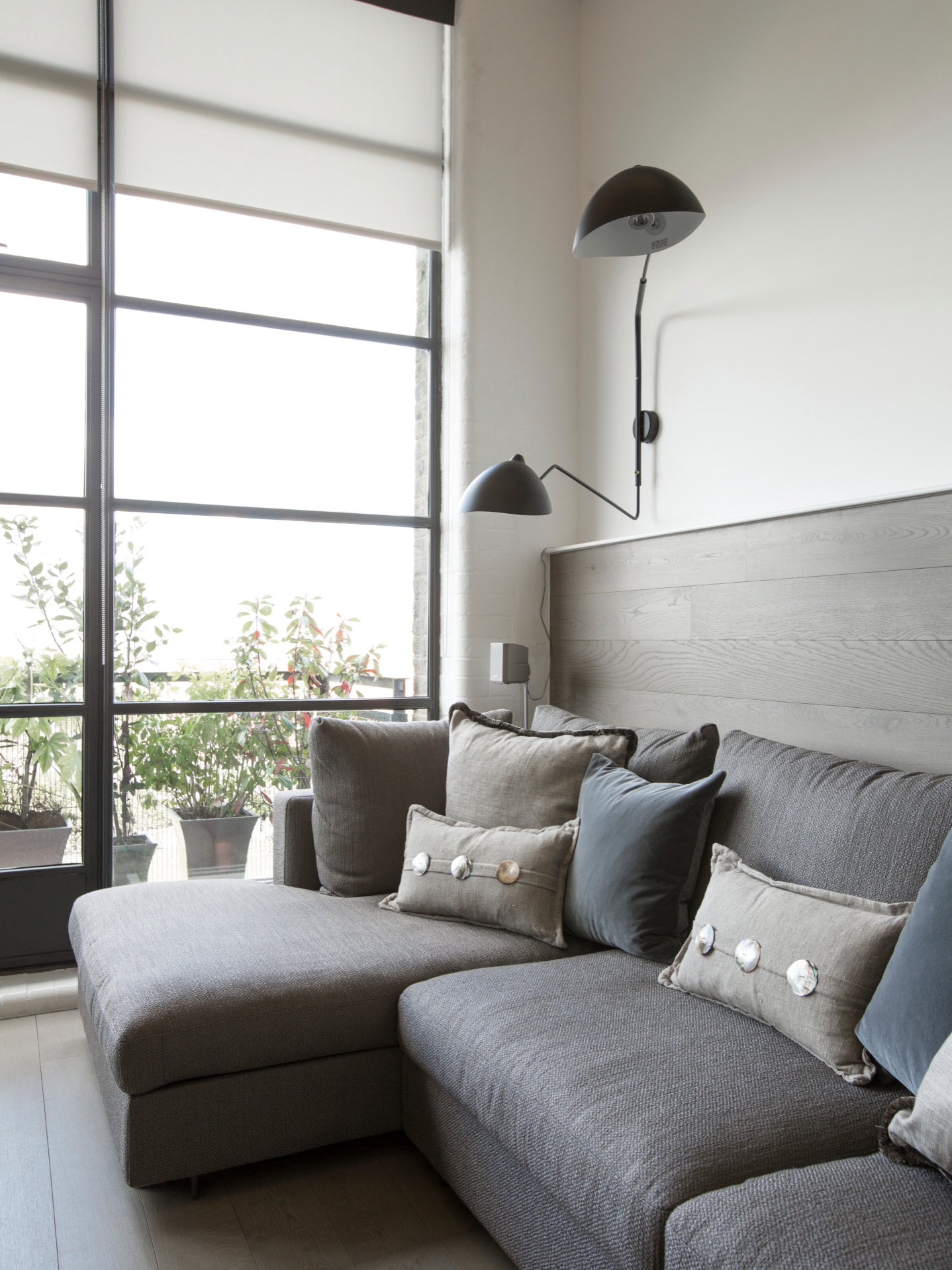 "Elegant Serge Mouille vegglampe med justerbar arm, insektlignende design, passer moderne innredning i svart eller hvit."