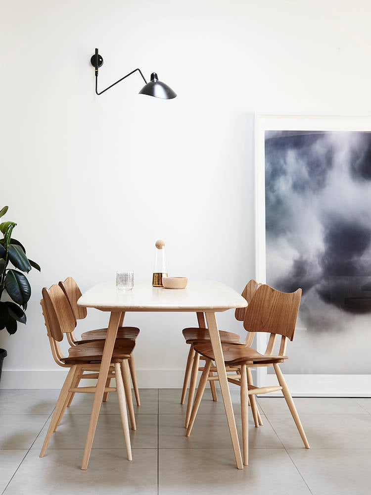 "Elegant Serge Mouille vegglampe med justerbar arm, insektlignende design, passer moderne innredning i svart eller hvit."