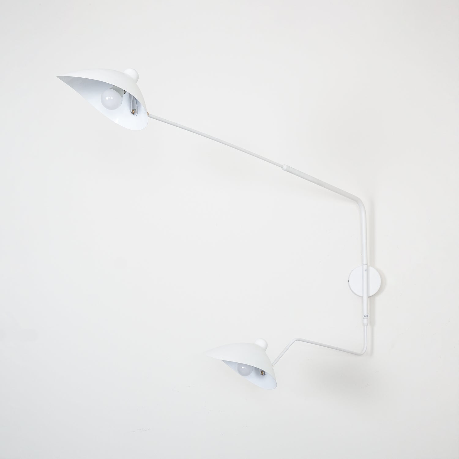 "Elegant Serge Mouille vegglampe med justerbar arm, insektlignende design, passer moderne innredning i svart eller hvit."