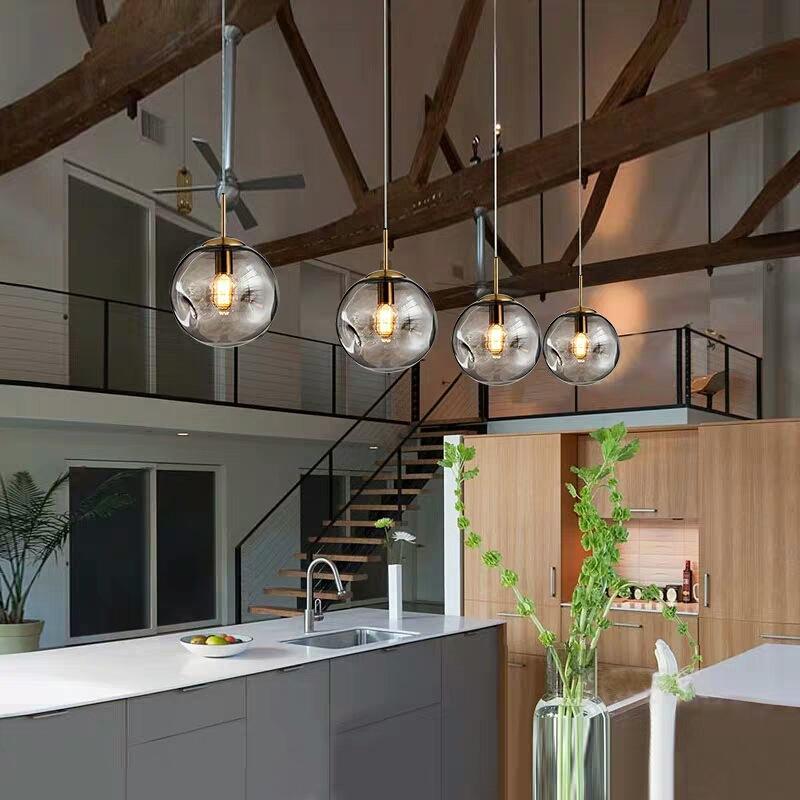 "Elegant sfærisk glasspendellampe med gullfinish, nordisk design, jevn lysfordeling, passer for moderne innemiljøer."